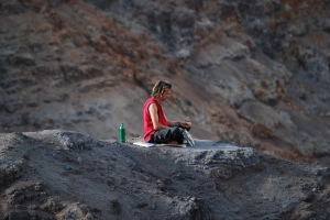 Man meditating on a cliff at Kauai's Waimea Canyon.